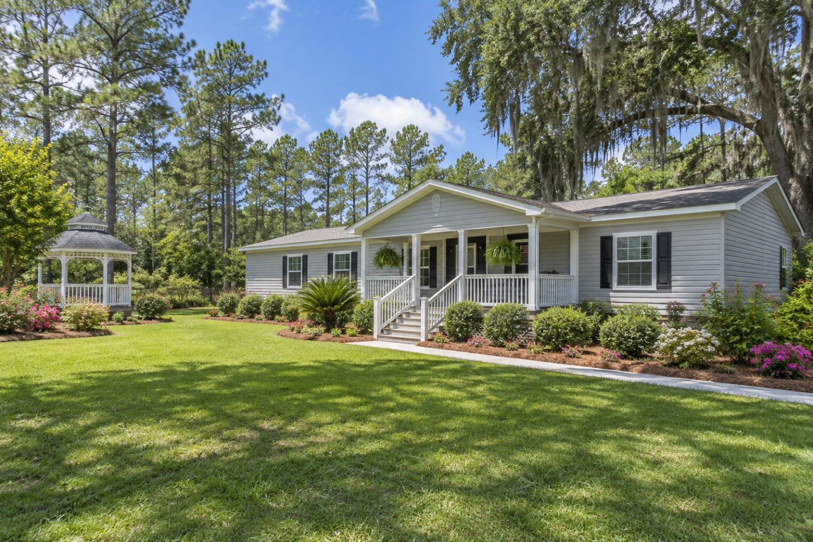 Double-wide manufactured home with flower gardens and a gazebo